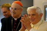 Pope Benedict gestures onboard the plane from Rome to Australia