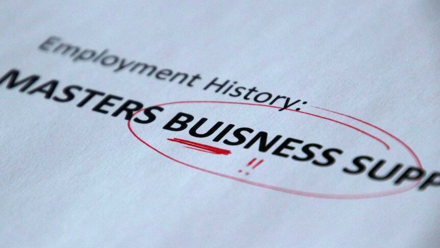A printed piece of paper with the misspelt word 'Buisness' circled with a red pen.