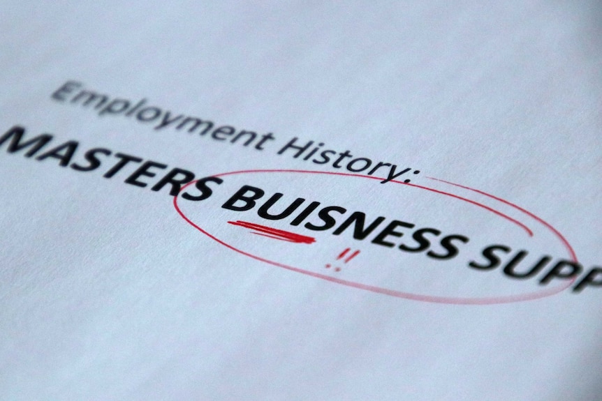 A printed piece of paper with the misspelt word 'Buisness' circled with a red pen.