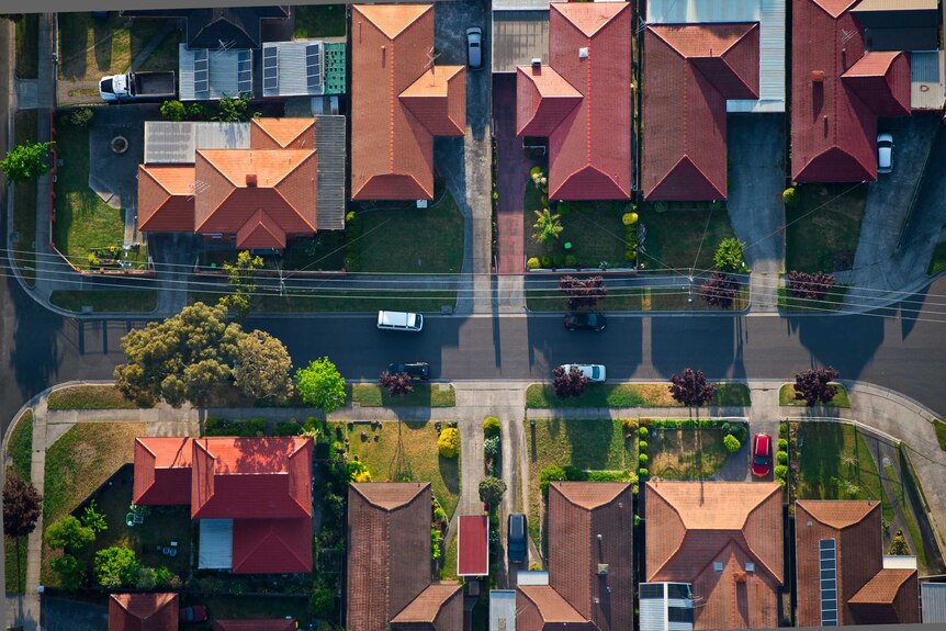 An aerial shot of a street, featuring houses, roads and cars, in Melbourne suburbs.