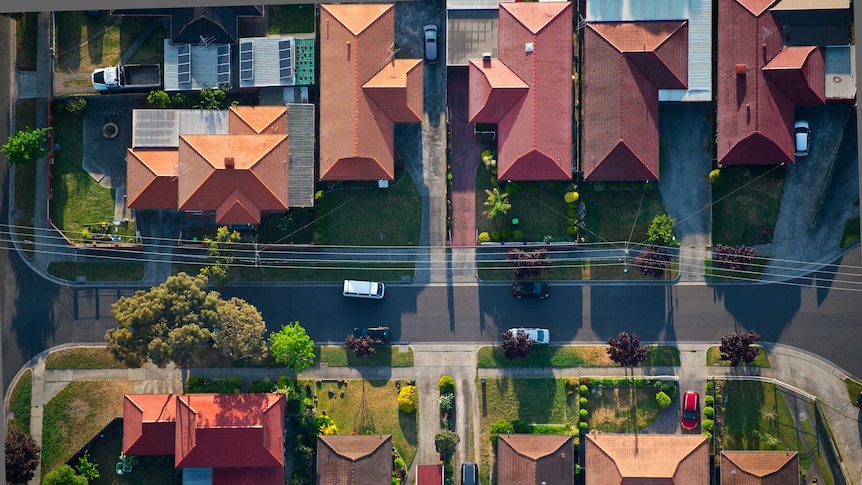 An aerial shot of a street, featuring houses, roads and cars, in Melbourne suburbs.