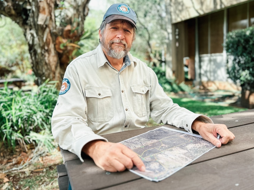 a man in a ranger uniform sits at a table with a map
