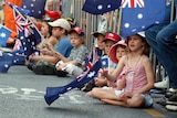 Kids waving the Australian flag at Anzac parade in Brisbane