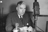 Black and white photo of Menzies in front of a radio microphone.
