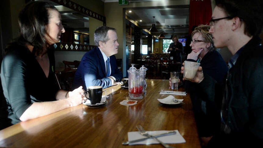 Bill Shorten (2nd left) and Gai Brodtman (left) speak with locals at a cafe in Canberra.