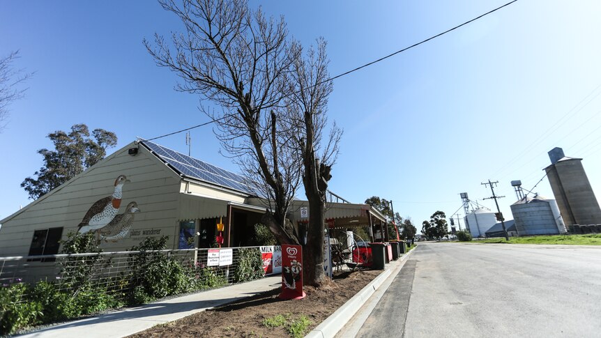 A country Australian town streetscape with grain silos and a corner store