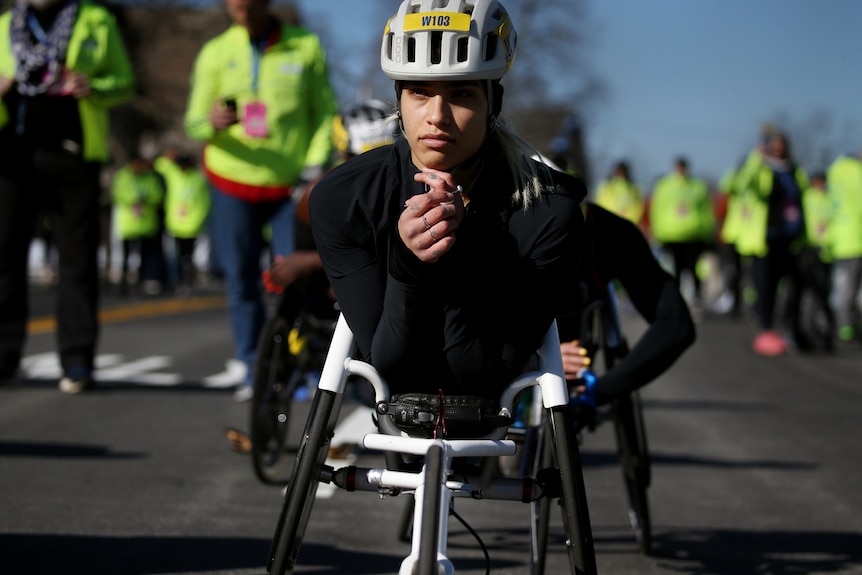 Madison de Rozario sits in her race wheelchair wearing a helmet before the Boston Marathon.