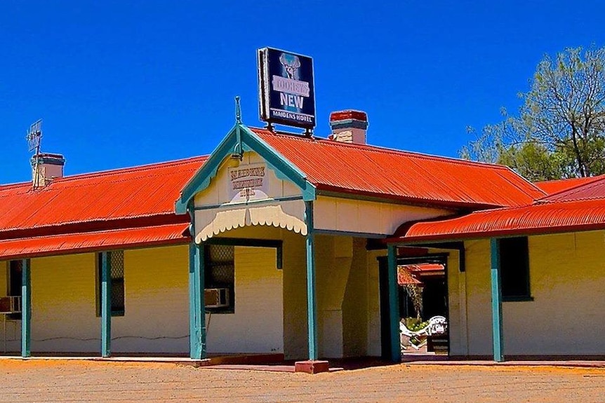 The brick red roof of the Maiden Hotel in Menindee contrasts vibrantly against the blue sky.