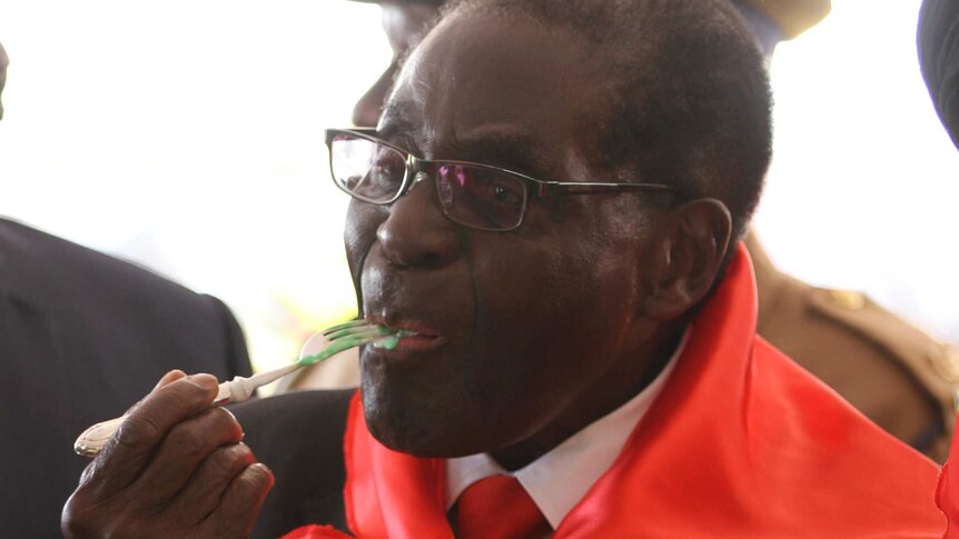 Zimbabwe's president Robert Mugabe eats a slice of cake during celebrations marking his 90th birthday.