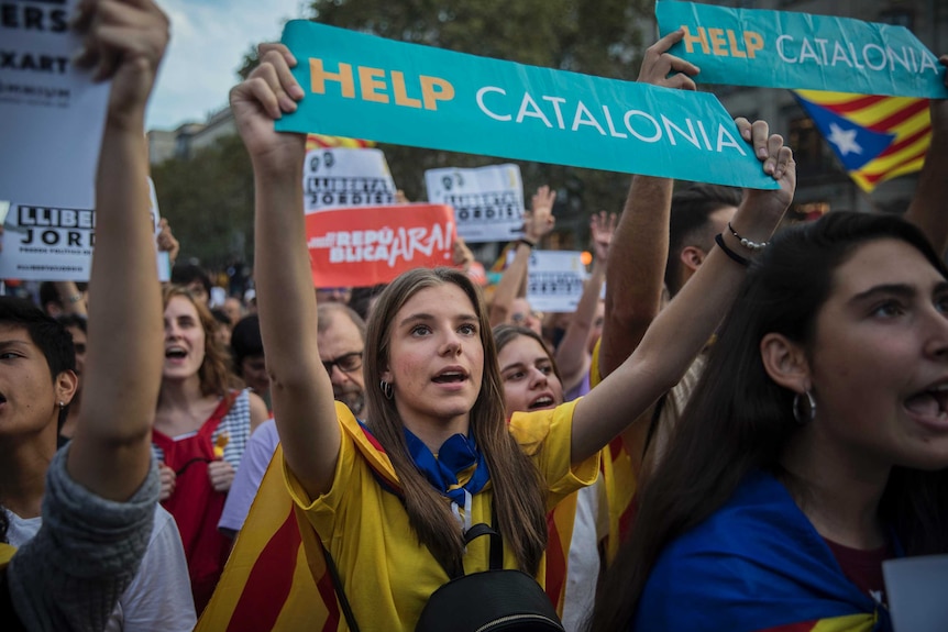 Catalan protesters hold up a sign that reads Help Catalonia.