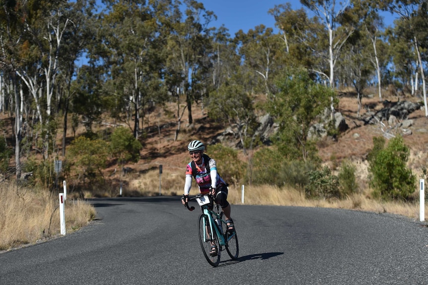 Mary Garden participating in a cycling road race in the bush.