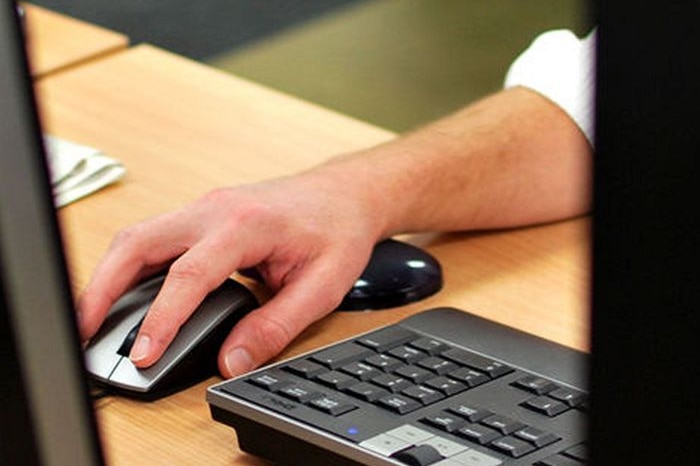 A hand rests on a computer mouse