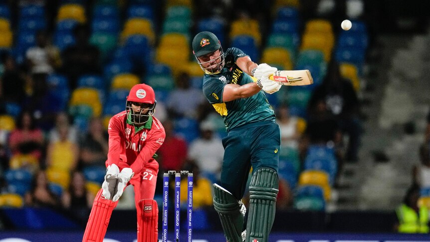 Australia batter Marcus Stoinis follows through with a shot, with the ball airborne, heading for six runs