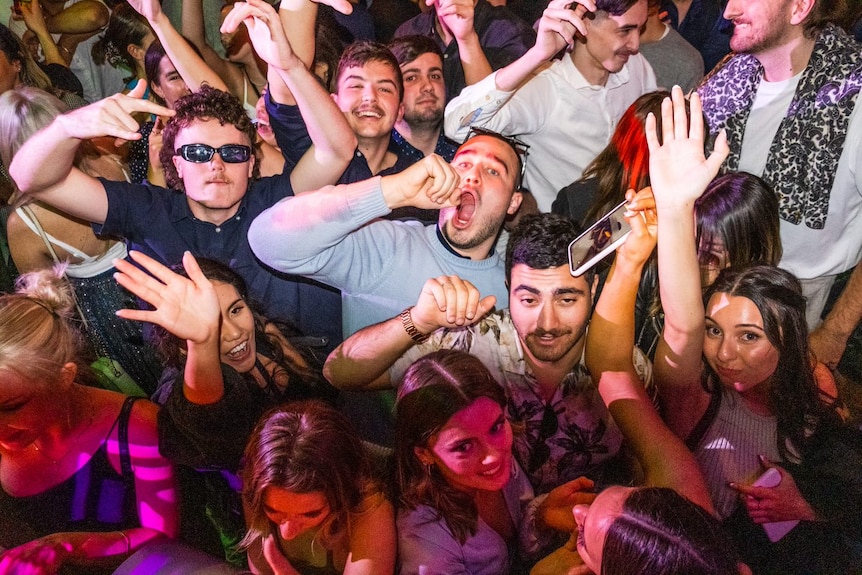 a group of people raising their hands and singing