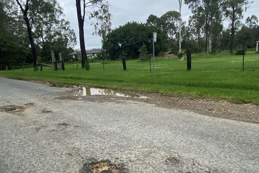 Potholed road with no footpath