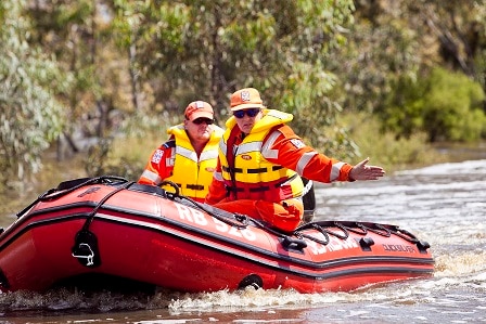 Two SES volunteers in a boat in a river