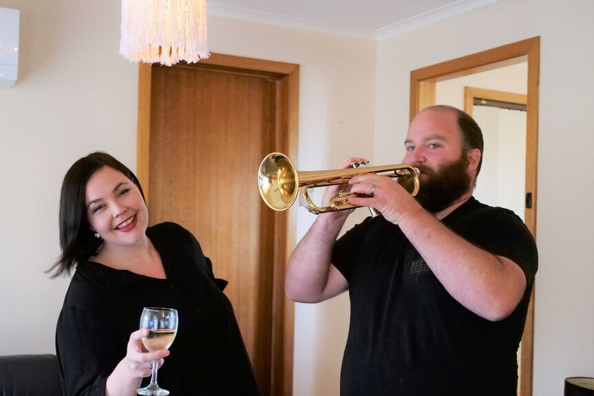 A woman dancing and a man playing the trumpet.