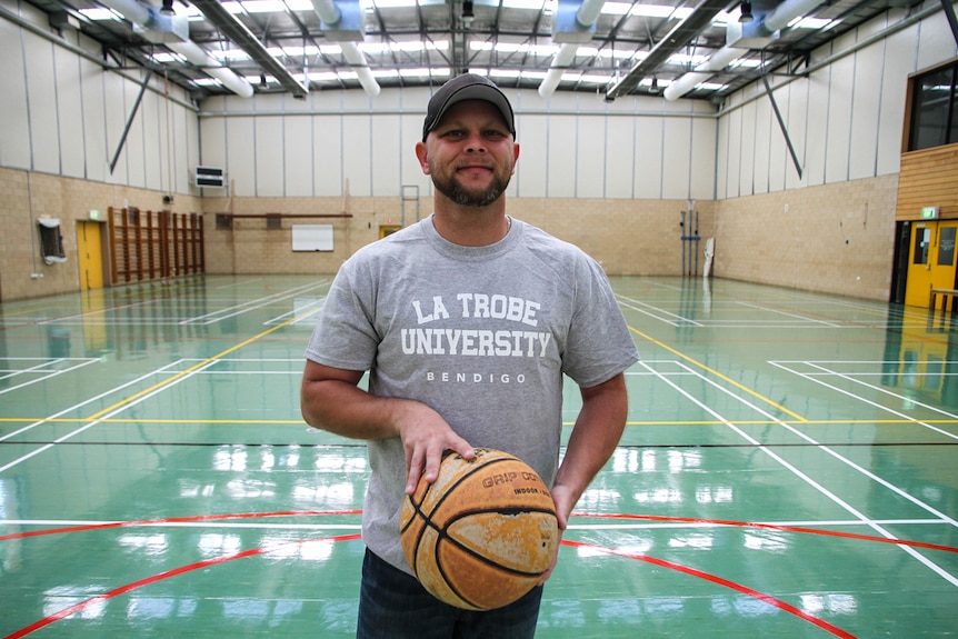 Ex-law enforcement officer from the US Jesse Poole on the basketball court holding  a basketball.