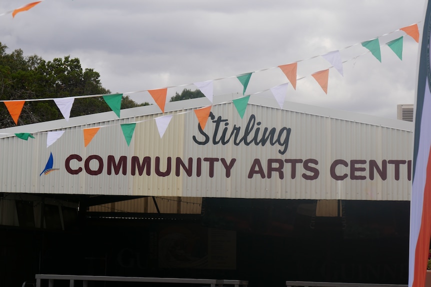 The front of Stirling Community Arts Centre with colourful flags in front of the name.