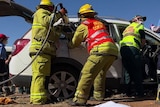 Numerous emergency services people attend a fake car crash.