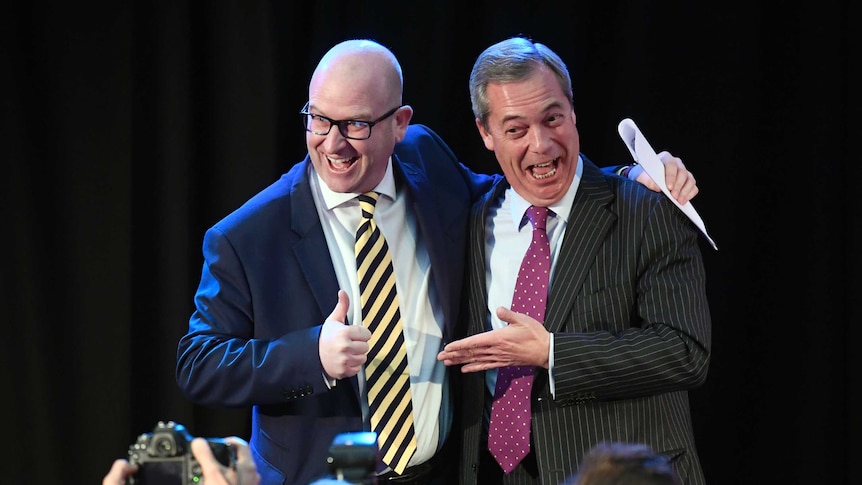 UKIP interim leader Nigel Farage (R) embraces newly elected leader Paul Nuttall (L).