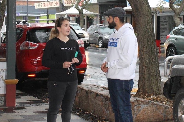 Imam Kamran Tahir chats to a woman on the street.