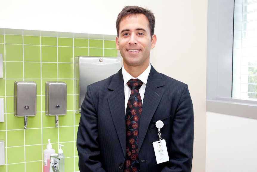 Aron Chakera wears a suit in a hospital setting