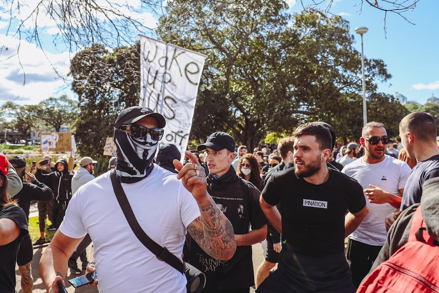 A large group of people, pointing and shouting