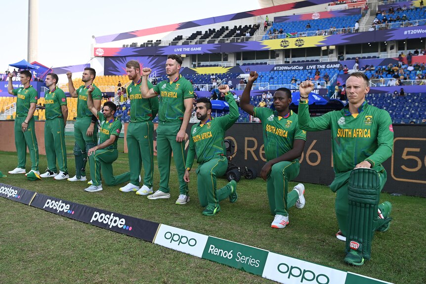 Some cricket players take a knee while other stand with their fists raised and others just stand
