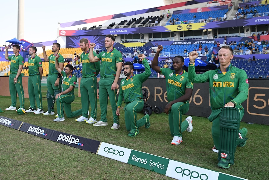 Some cricket players take a knee while other stand with their fists raised and others just stand