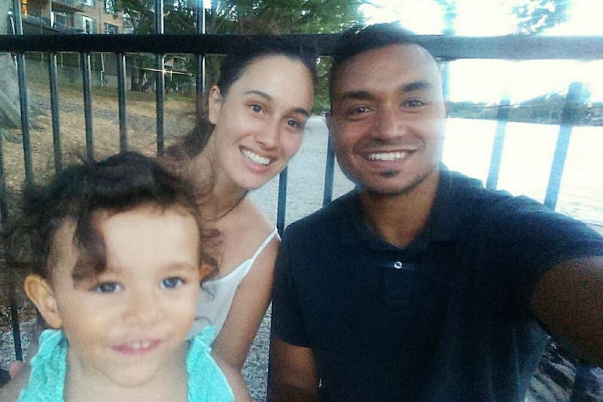 Family of three, Mum, Dad and small daughter, take a selfie outdoors. 