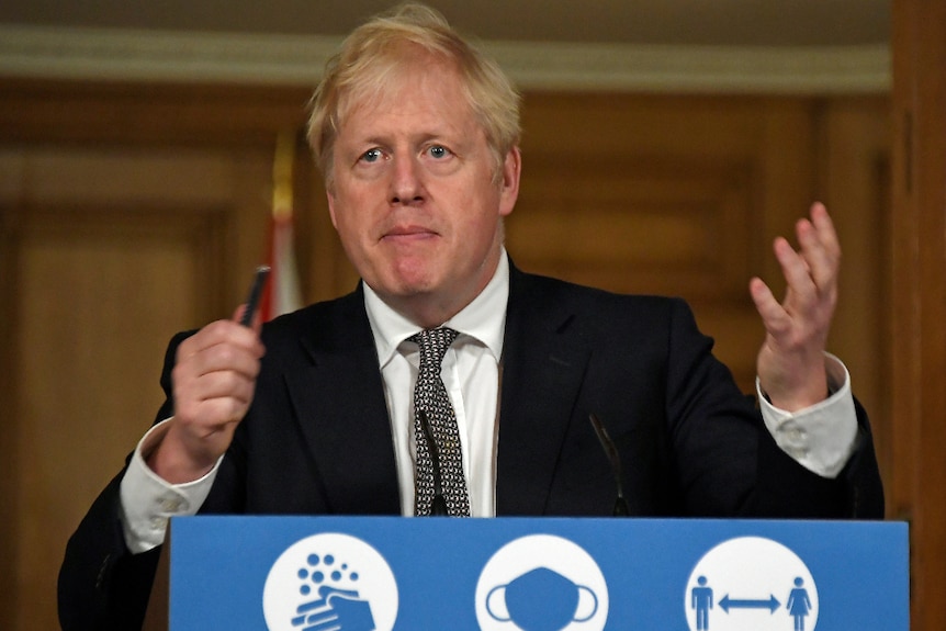 British Prime Minister Boris Johnson gestures as he speaks at a lectern