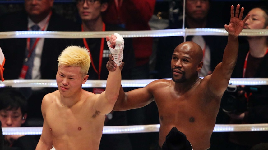Floyd Mayweather Jr. (R), with Japanese kickboxer Tenshin Nasukawa, after beating him in Saitama.