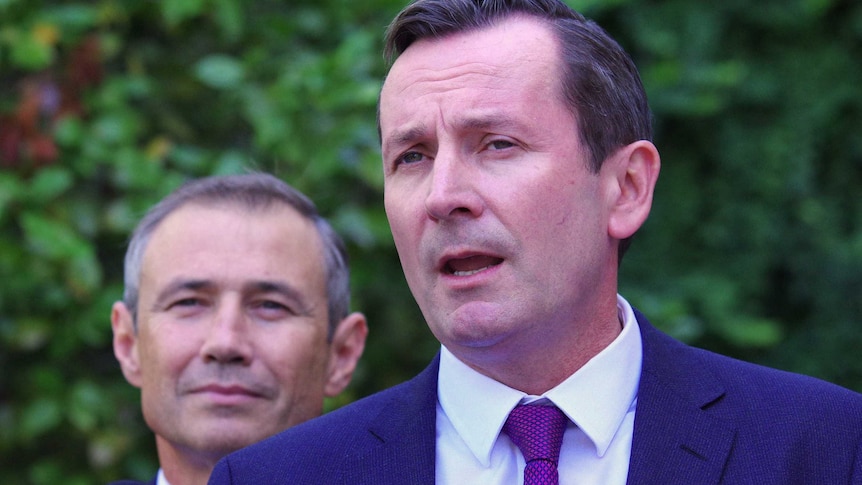 Headshot of Mark McGowan with Roger Cook behind him.