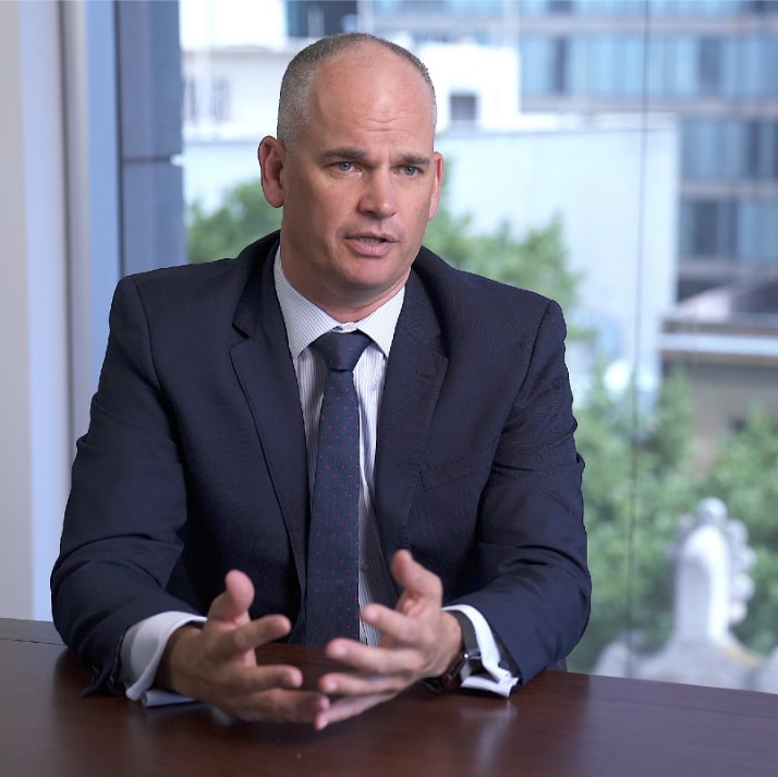 Munro Partners chief investment officer Nick Griffin sits in front of a window in an office.