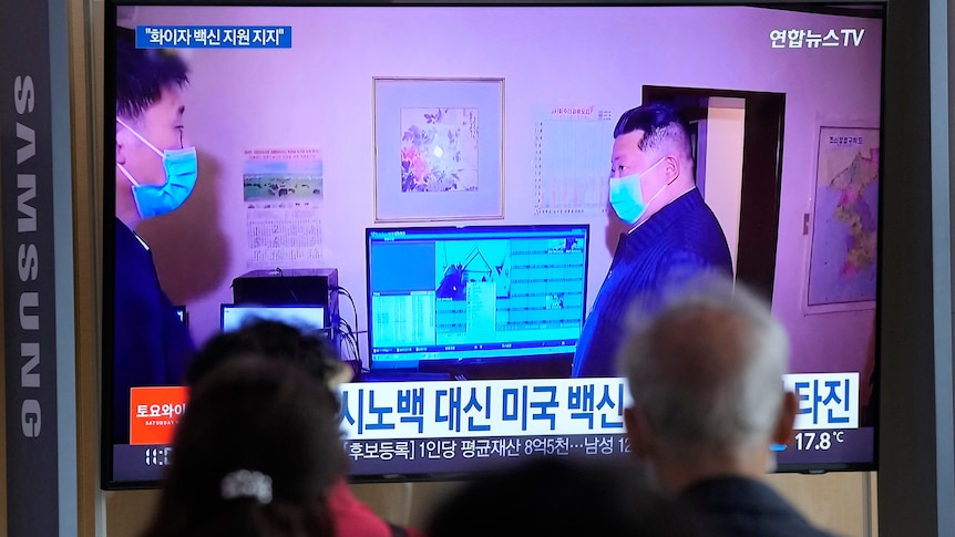People watch a TV screen showing North Korean leader Kim Jong Un
