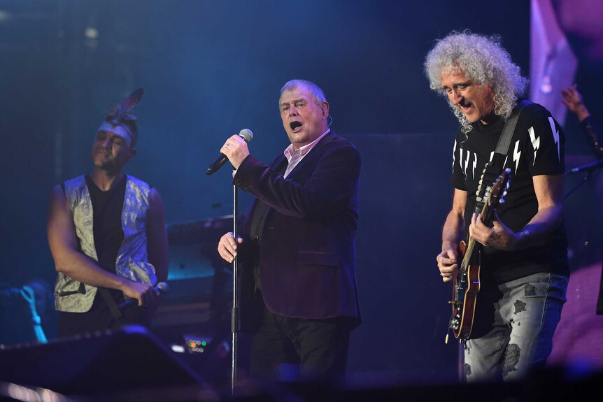 Mitch Tambo, John Farnham and Brian May perform on stage
