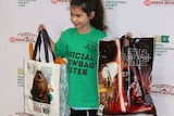 A girl holds up show bags for Star Wars and the Secret Life of Pets.