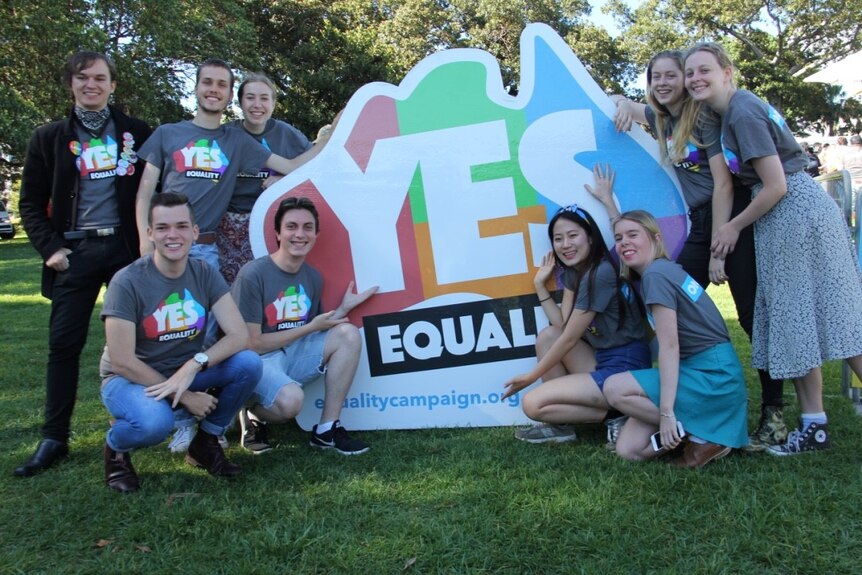 Ten volunteers stand near the equality map of Australia