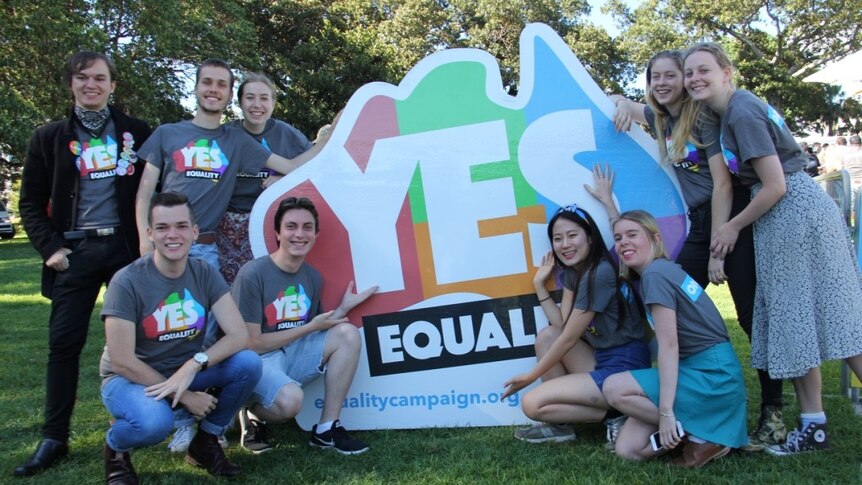 Ten volunteers stand near the equality map of Australia
