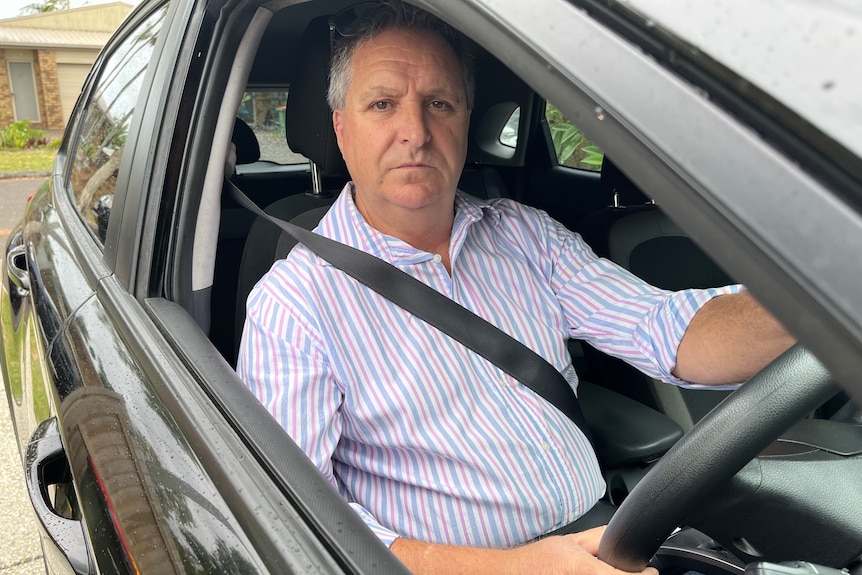 Paul Collins, Sunshine Coast Uber driver, in his car looking displeased