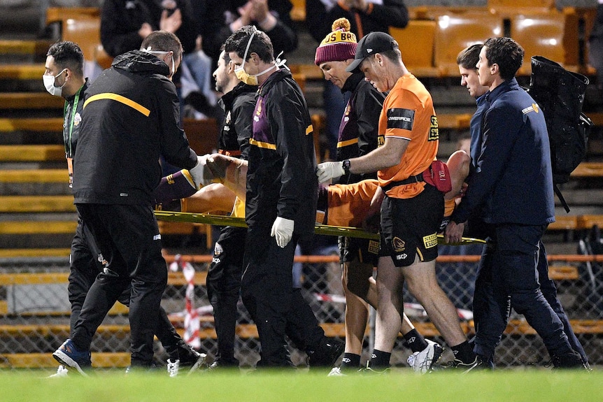 A Brisbane Broncos NRL player is taken from the field on a stretcher after sustaining an injury against Wests Tigers.