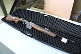 A new Verney-Carron Speedline rifle lies in an open gun case on a table with a tag on its barrel.
