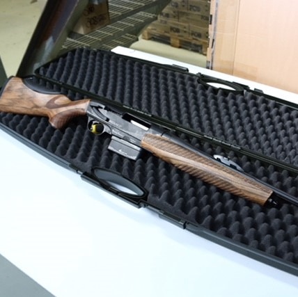 A new Verney-Carron Speedline rifle lies in an open gun case on a table with a tag on its barrel.