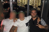 A photo taken from Facebook shows Andrew Morrison posing with two friends whose faces have been blurred out.