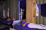 Men sleep outdoors on bunk beds at the old detention centre in Manus