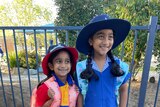 Two smiling girls in school uniform.