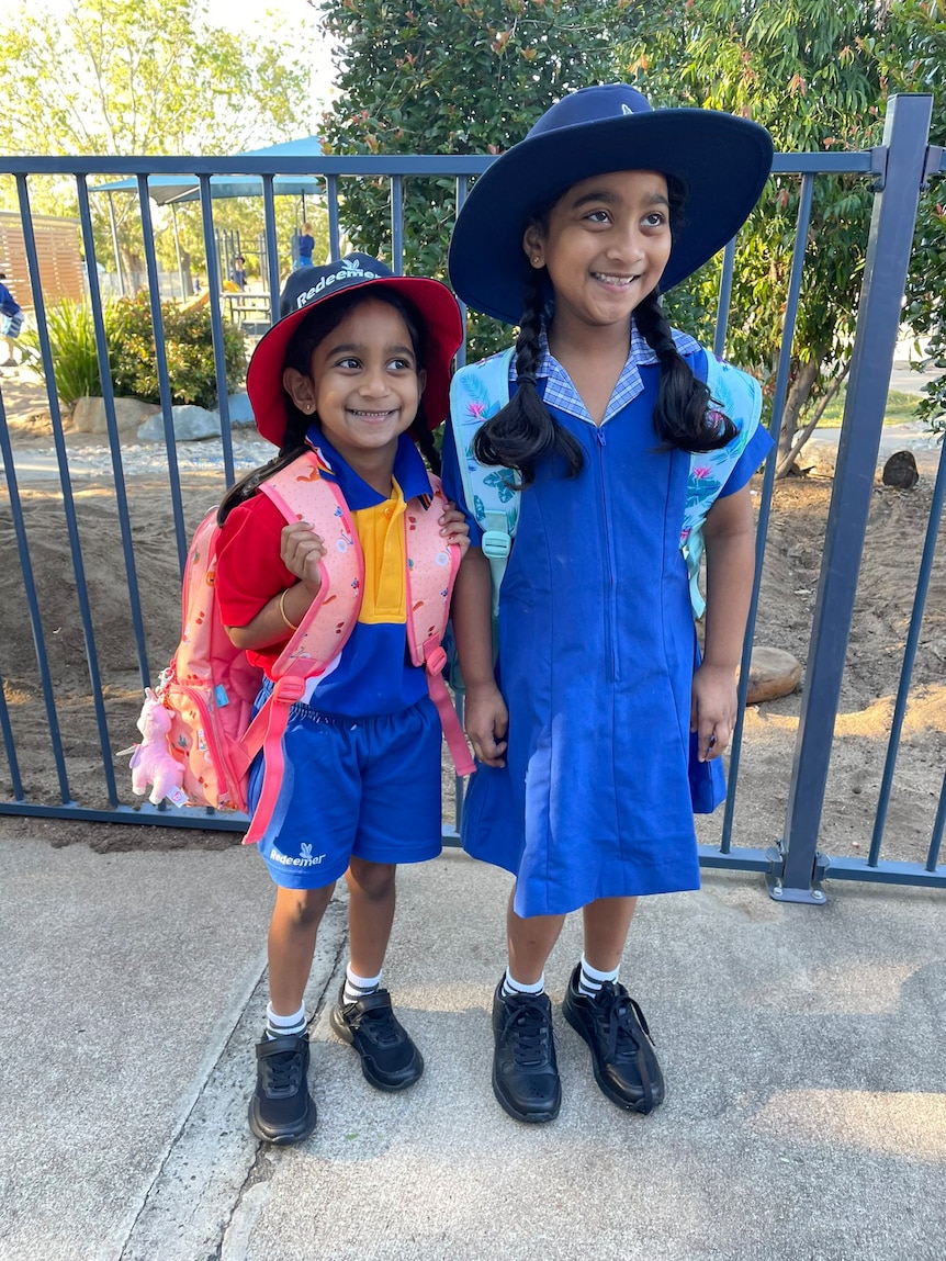 Two smiling girls in school uniform.