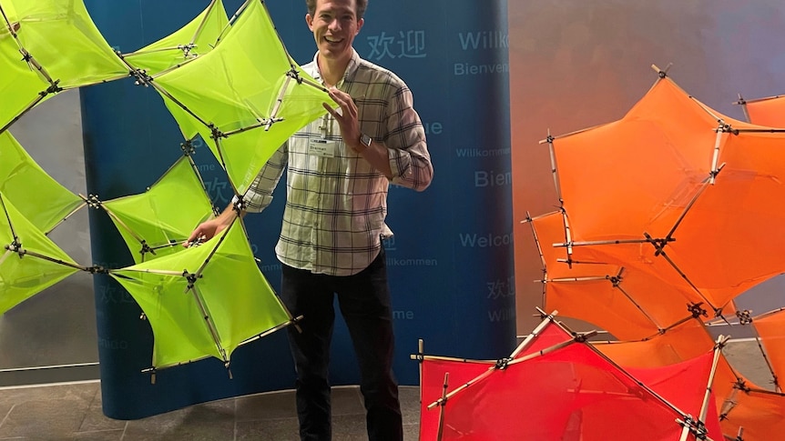 Dylan Sherman stands within a human scale model of his material to show where carbon dioxide could be bonded.