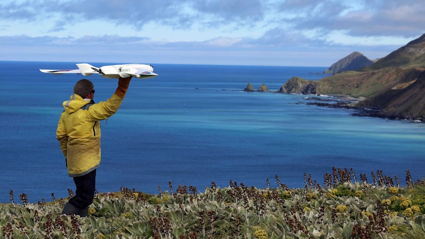 Ecologist  Jarrod Hodgson launches an unmanned aircraft.